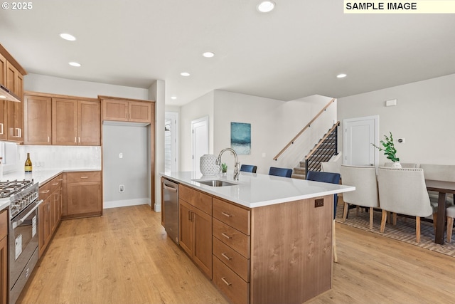 8276 SE Orion Ln, Hillsboro, OR 97123 - kitchen with a sink, stainless steel appliances, light wood-style flooring, brown cabinets, and recessed lighting