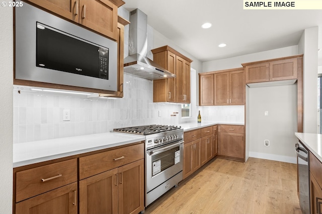 8276 SE Orion Ln, Hillsboro, OR 97123 - kitchen featuring stainless steel appliances, wall chimney exhaust hood, brown cabinetry, light wood finished floors, and light countertops
