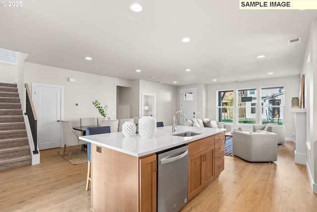 8276 SE Orion Ln, Hillsboro, OR 97123 - kitchen with stainless steel dishwasher, a sink, light wood-type flooring, a kitchen island with sink, and recessed lighting