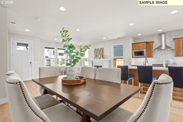 8276 SE Orion Ln, Hillsboro, OR 97123 - dining room featuring recessed lighting, light wood finished floors, a tiled fireplace, and baseboards
