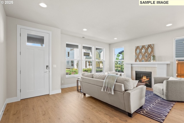 8276 SE Orion Ln, Hillsboro, OR 97123 - living room featuring light wood finished floors, a fireplace, plenty of natural light, baseboards, and recessed lighting