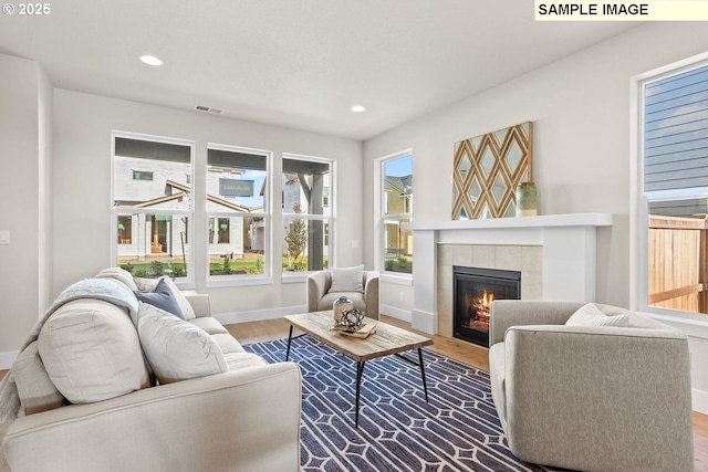 8276 SE Orion Ln, Hillsboro, OR 97123 - living room featuring wood finished floors, baseboards, a tiled fireplace, and recessed lighting