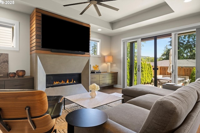 4480 Upper Dr, Lake Oswego, OR 97035 - living area featuring ceiling fan, a glass covered fireplace, recessed lighting, a tray ceiling, and wood finished floors