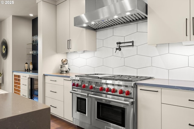 4480 Upper Dr, Lake Oswego, OR 97035 - kitchen featuring double oven range, wall chimney range hood, beverage cooler, white cabinets, and tasteful backsplash