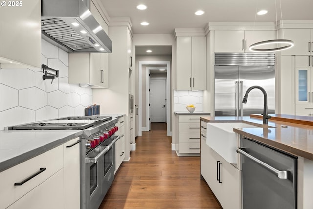 4480 Upper Dr, Lake Oswego, OR 97035 - kitchen featuring wall chimney exhaust hood, high quality appliances, backsplash, recessed lighting, and white cabinets