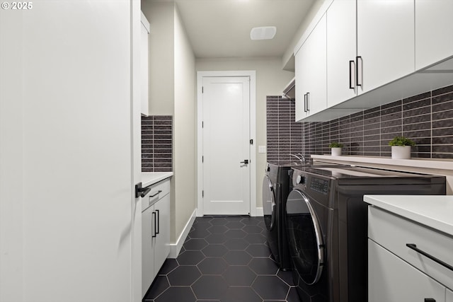 4480 Upper Dr, Lake Oswego, OR 97035 - laundry room with cabinet space, washer and clothes dryer, dark tile patterned floors, and baseboards