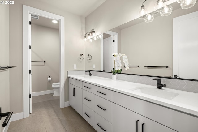 4480 Upper Dr, Lake Oswego, OR 97035 - bathroom featuring double vanity, toilet, baseboards, tile patterned flooring, and decorative backsplash