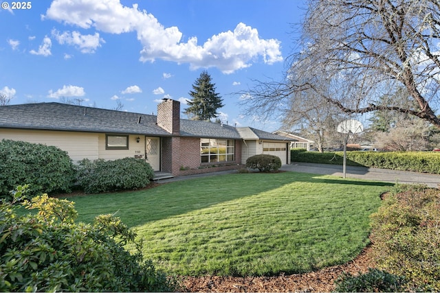 back of property with brick siding, a garage, a yard, and a chimney