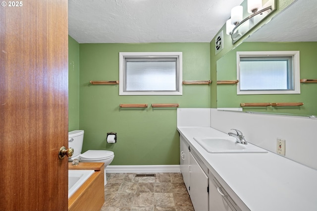 full bathroom with vanity, baseboards, visible vents, a textured ceiling, and toilet