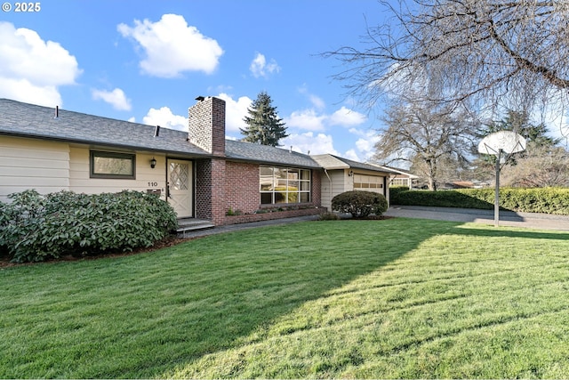 back of house with an attached garage, a lawn, brick siding, and a chimney