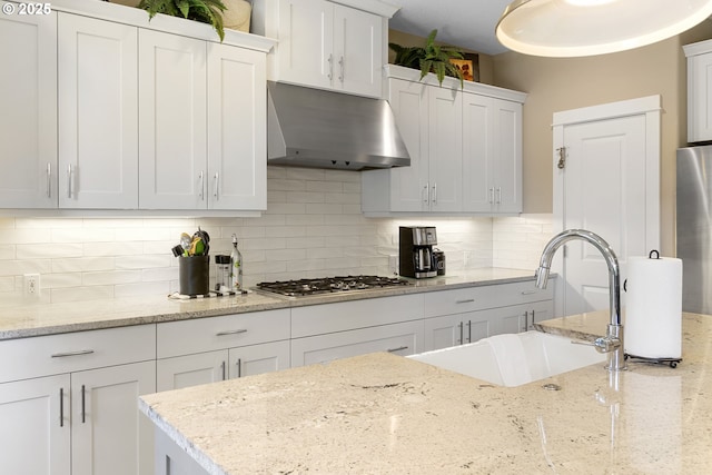 14206 SE Woodside Ave, Milwaukie, OR 97267 - kitchen featuring under cabinet range hood, stainless steel appliances, a sink, decorative backsplash, and white cabinetry