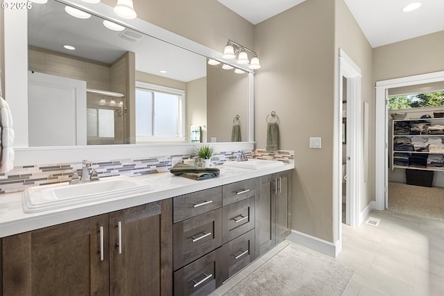 14206 SE Woodside Ave, Milwaukie, OR 97267 - bathroom with double vanity, backsplash, baseboards, a shower, and recessed lighting