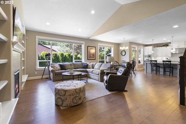 14206 SE Woodside Ave, Milwaukie, OR 97267 - living room featuring dark wood-type flooring, lofted ceiling, recessed lighting, a lit fireplace, and baseboards