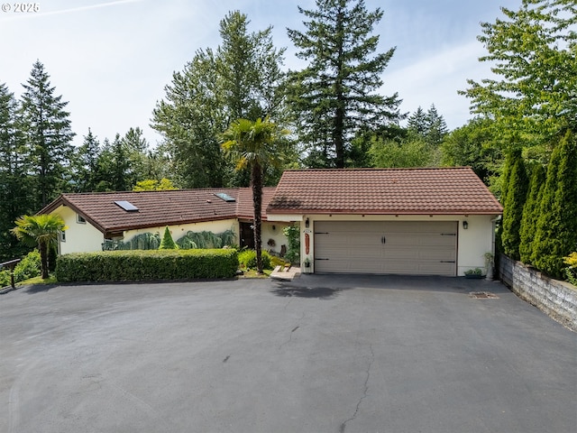 10059 SW 57th Pl, Portland, OR 97219 - view of front of home with a tiled roof, stucco siding, driveway, and a garage
