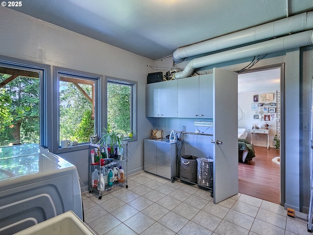 10059 SW 57th Pl, Portland, OR 97219 - laundry room featuring cabinet space, light tile patterned floors, and washing machine and clothes dryer