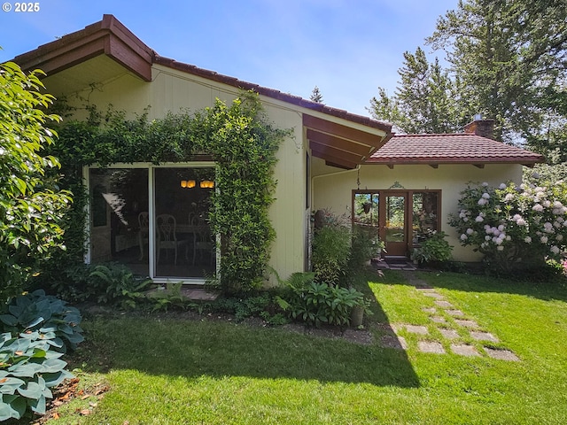 10059 SW 57th Pl, Portland, OR 97219 - view of front of property with a tiled roof, a front lawn, a chimney, and stucco siding