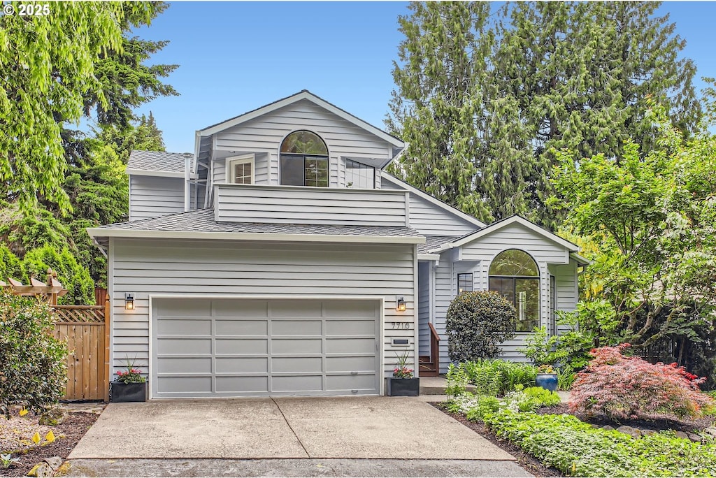 7710 SW Ruby Ter, Portland, OR 97219 - view of front facade with driveway, roof with shingles, and an attached garage