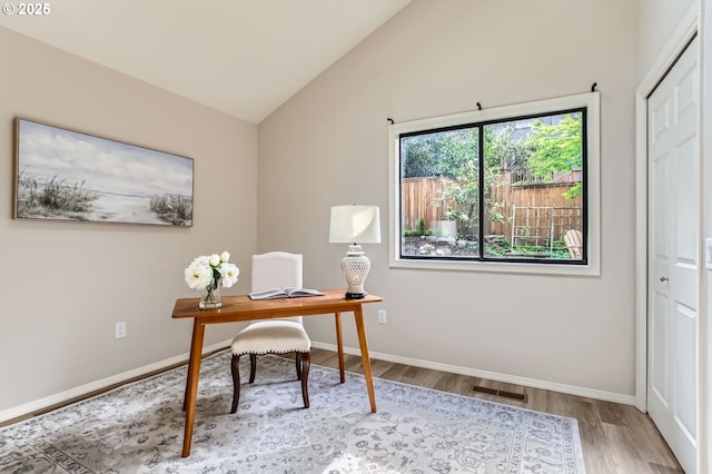 office area with wood finished floors, baseboards, and lofted ceiling