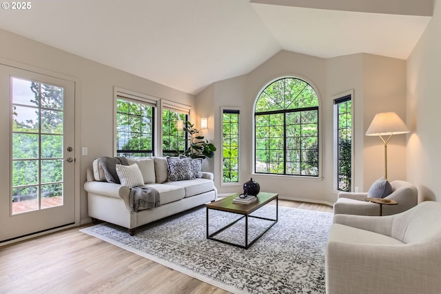 living room with plenty of natural light, wood finished floors, and lofted ceiling