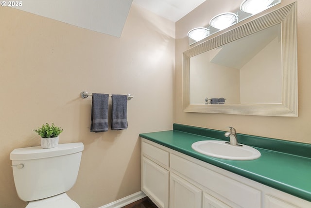 bathroom with vanity, toilet, and baseboards