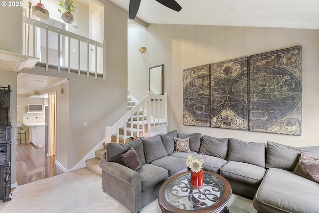 living room with stairs, vaulted ceiling, wood finished floors, and baseboards