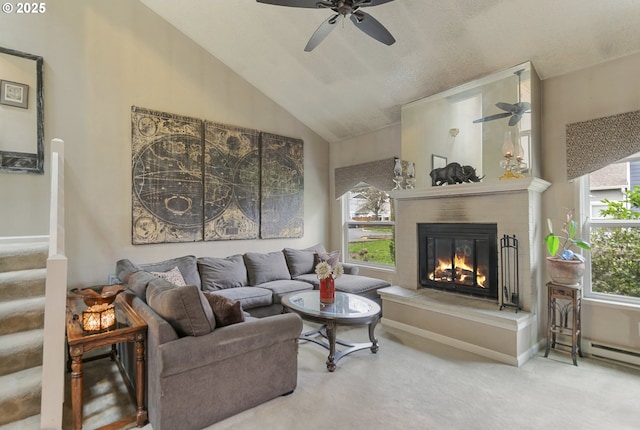 carpeted living area featuring stairs, vaulted ceiling, a wealth of natural light, and a glass covered fireplace