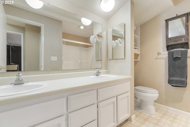 full bathroom with baseboards, a sink, toilet, and double vanity