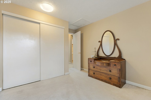 unfurnished bedroom with carpet, a closet, a textured ceiling, and baseboards