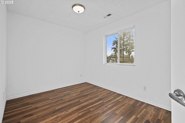 spare room featuring dark hardwood / wood-style flooring