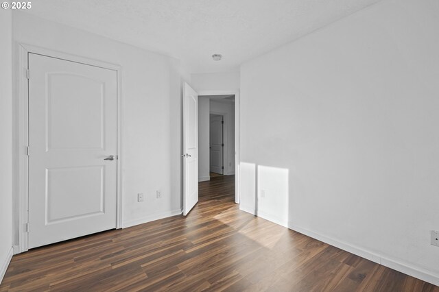 unfurnished bedroom with dark hardwood / wood-style flooring