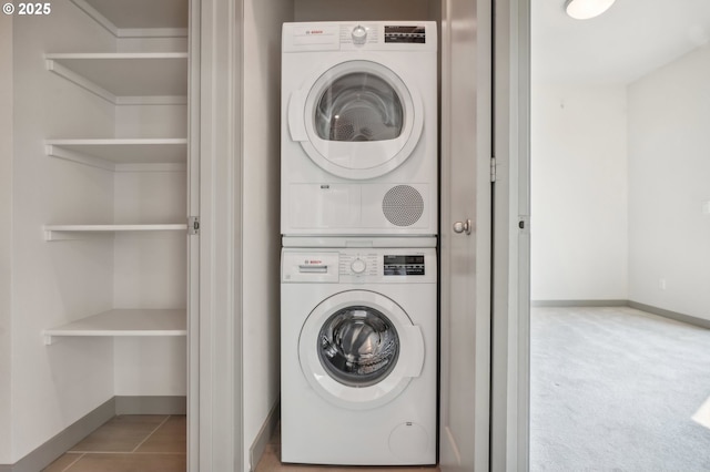 clothes washing area with light carpet and stacked washing maching and dryer