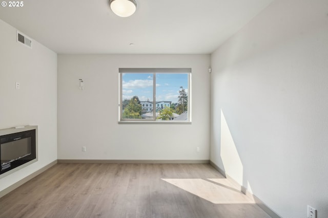 unfurnished living room with heating unit and light hardwood / wood-style floors