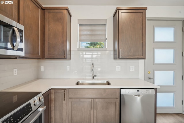 kitchen with stainless steel appliances, backsplash, and sink