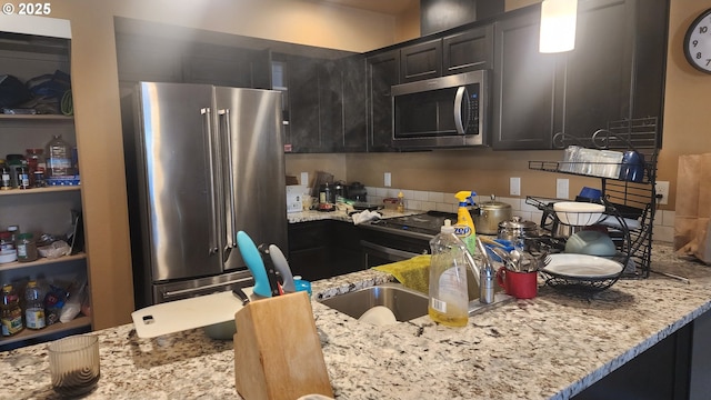 kitchen with stainless steel appliances and light stone countertops