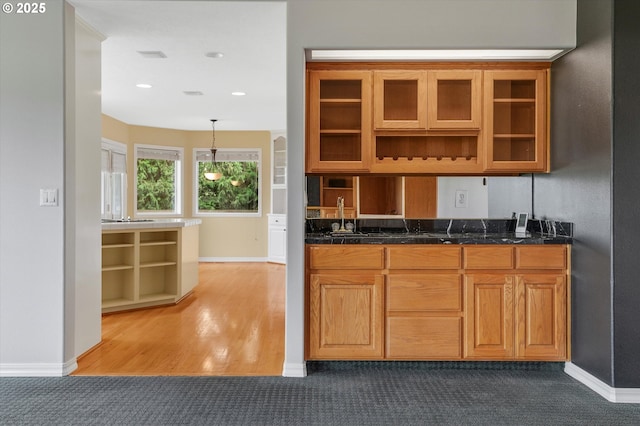 kitchen with dark countertops, glass insert cabinets, and brown cabinets