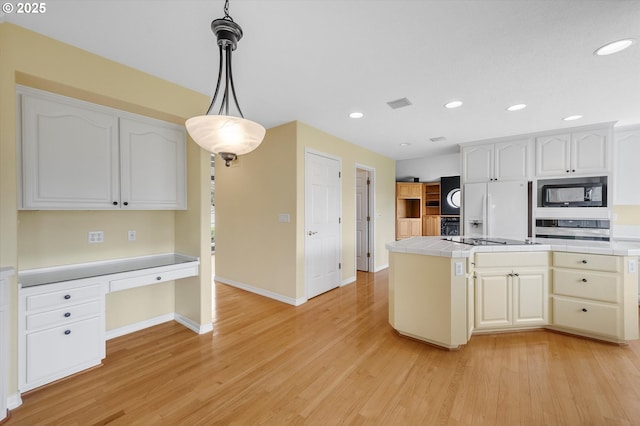 kitchen featuring oven, tile counters, built in microwave, built in desk, and white fridge with ice dispenser