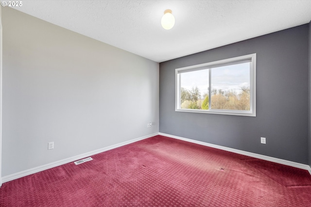 empty room featuring visible vents, a textured ceiling, baseboards, and carpet floors