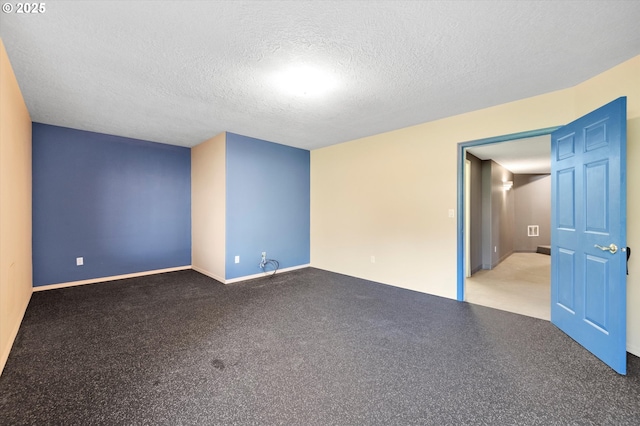 spare room featuring a textured ceiling and carpet floors