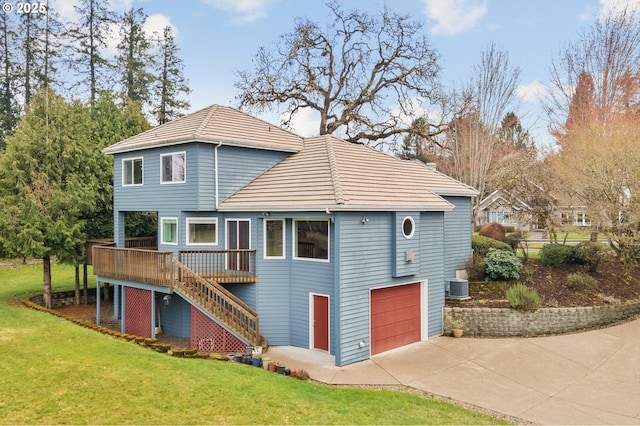 back of house with central AC unit, a yard, an attached garage, stairs, and concrete driveway