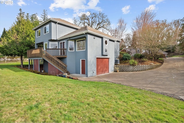 view of side of home with stairway, a yard, concrete driveway, an attached garage, and a wooden deck