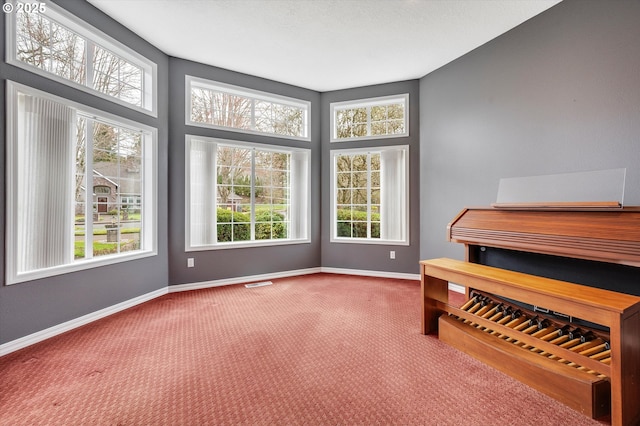 living area with visible vents, baseboards, and carpet flooring