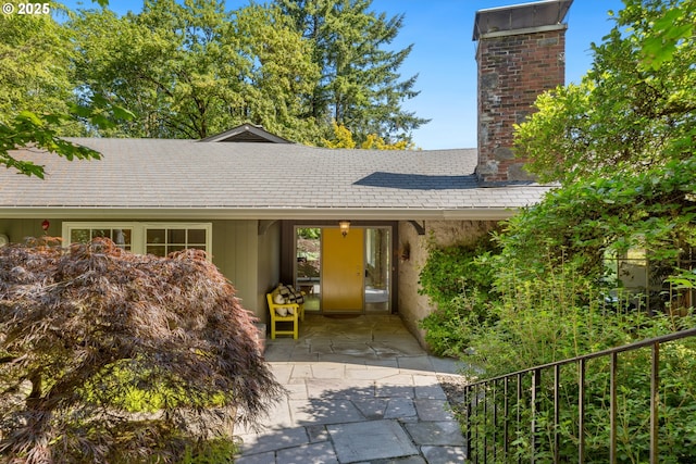 3925 SW Humphrey Blvd, Portland, OR 97221 - view of front facade featuring a chimney, a patio, and a shingled roof
