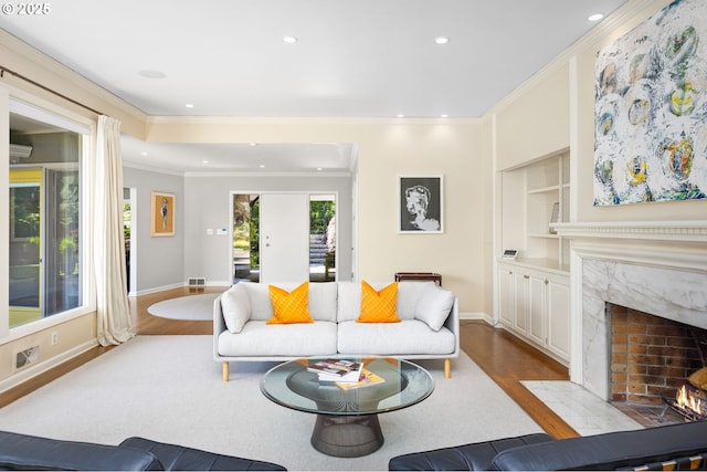 3925 SW Humphrey Blvd, Portland, OR 97221 - living area featuring wood finished floors, recessed lighting, a high end fireplace, crown molding, and built in shelves