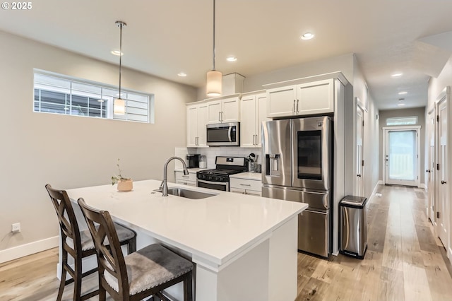 4451 SE Hardwood Ln, Hillsboro, OR 97123 - kitchen with stainless steel appliances, a sink, tasteful backsplash, light wood-style floors, and recessed lighting