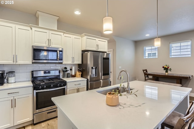 4451 SE Hardwood Ln, Hillsboro, OR 97123 - kitchen with stainless steel appliances, a sink, decorative backsplash, light wood finished floors, and light countertops