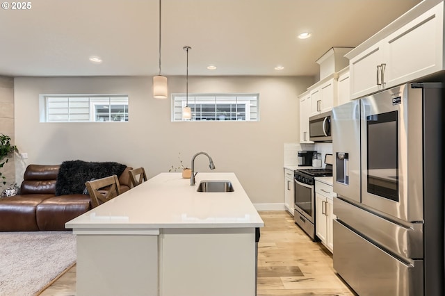 4451 SE Hardwood Ln, Hillsboro, OR 97123 - kitchen featuring appliances with stainless steel finishes, a sink, open floor plan, light countertops, and light wood-style floors
