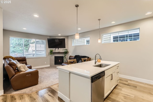 4451 SE Hardwood Ln, Hillsboro, OR 97123 - kitchen with a sink, stainless steel dishwasher, open floor plan, a tiled fireplace, and baseboards