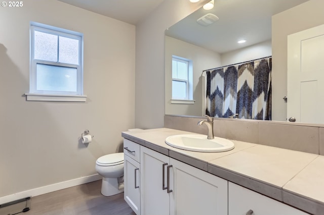 4451 SE Hardwood Ln, Hillsboro, OR 97123 - full bath featuring wood finished floors, baseboards, toilet, and healthy amount of natural light