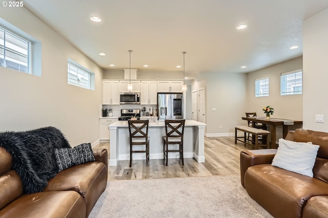 4451 SE Hardwood Ln, Hillsboro, OR 97123 - living room with recessed lighting, plenty of natural light, light wood finished floors, and baseboards