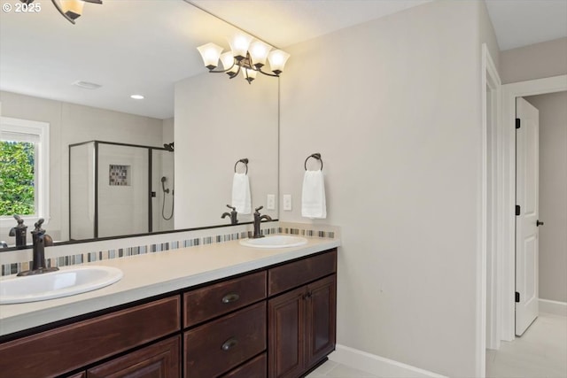 full bathroom with a shower stall, double vanity, baseboards, a chandelier, and tile patterned flooring